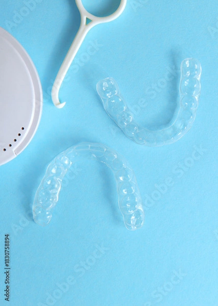 Fototapeta Vertical photo format.Aligners for straightening teeth on a blue background