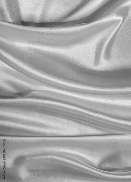 Fototapeta Silky, smooth gray satin fabric drapes with flowing folds and a reflective sheen, creating an elegant textile background.
