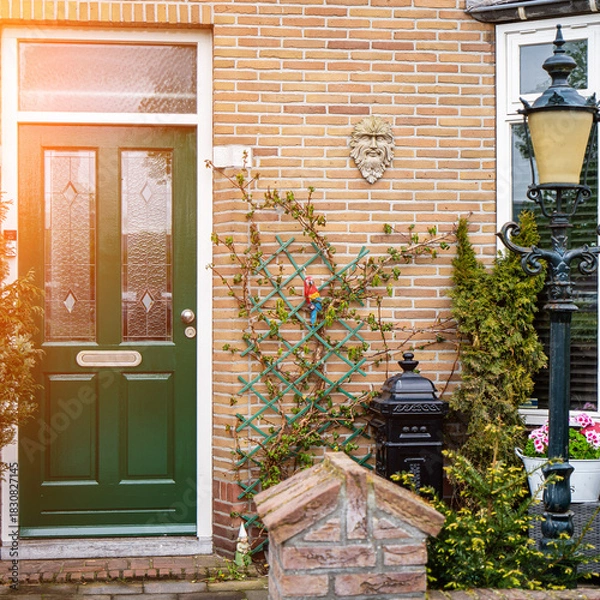 Fototapeta Facade of typical Dutch door house with brick walls, steps, front door windows. Doors on the street, Netherlands