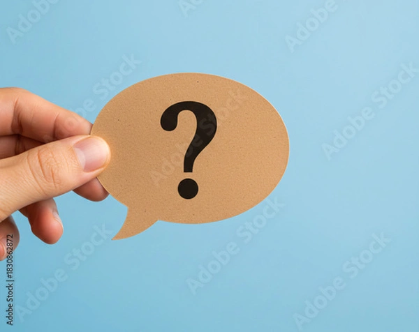 Fototapeta Hand Holding Question Mark Speech Bubble on Blue Background Symbolizing Inquiry and Curiosity, Communication Concept