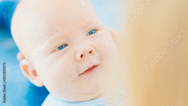 Obraz Mother plays with her newborn son with deep blue eyes in a bright room