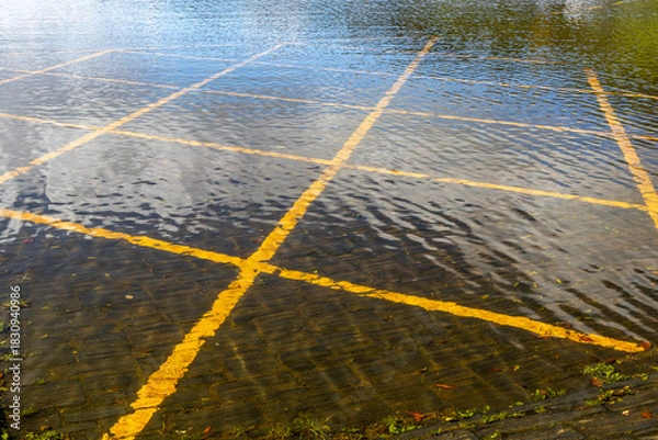 Fototapeta Flooded car park with submerged yellow lines