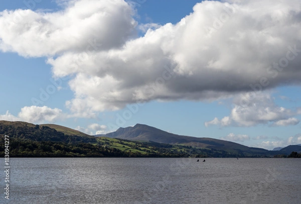 Fototapeta Two kayakers in distance on Bala Lake with distant hills and drifting clouds