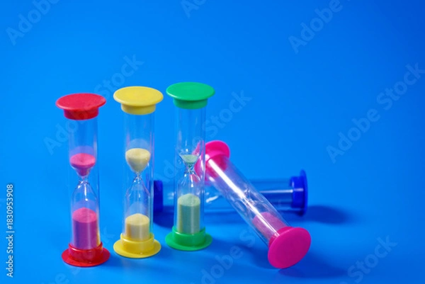 Obraz Hourglasses on blue background with copy space