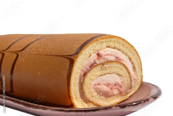 Fototapeta Close-up of a Swiss roll slice showing strawberry cream filling on a plate, isolated on white. Soft sponge spiral with glossy berry swirls and chocolate lines.