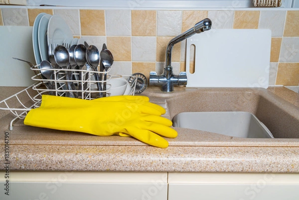 Fototapeta A pair of yellow washing up gloves next to the kitchen sink after the washing up has been done