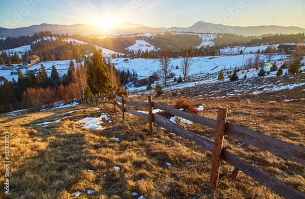 Fototapeta Rustic wooden fence on a mountain meadow with snowy peaks in the background.
