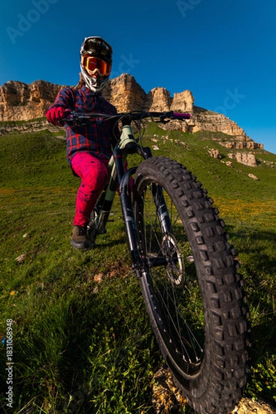 Obraz Nature and mountain biking, morning training and extreme sports on the trail. A man cycling outdoors against a backdrop of rocky mountains