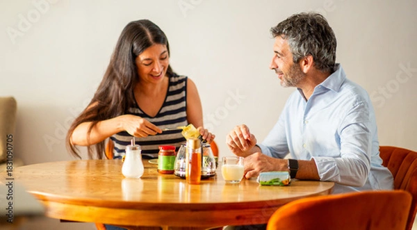 Obraz Smiling couple preparing toast together during cozy breakfast time