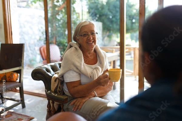 Obraz Senior woman smiling enjoying coffee during conversation