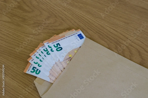 Obraz Fanned stack of 50 Euro notes peeking out from a brown manila envelope, implying a secret delivery of money