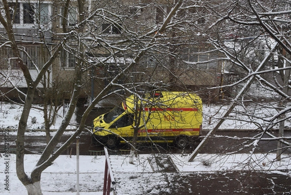 Obraz An ambulance near a multi-story reinforced concrete panel building. Winter in a Russian city. Typical residential development in Russia.