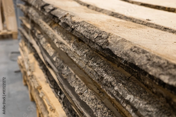 Fototapeta Stacked logs with textured bark fill the frame, showcasing natural wood grain. Concept of sustainable forestry, raw materials, or rustic construction is conveyed.