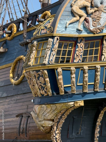 Obraz An ornate ship stern displays detailed carvings and craftsmanship under blue sky during daylight