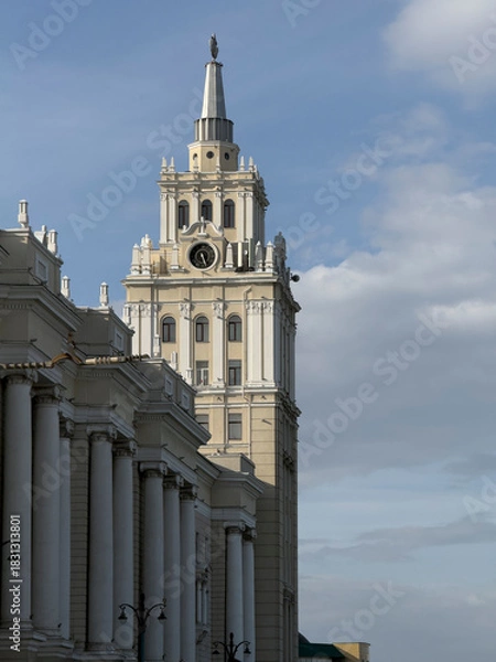 Obraz A beautiful clock tower is visible among classic architectural features and clouds