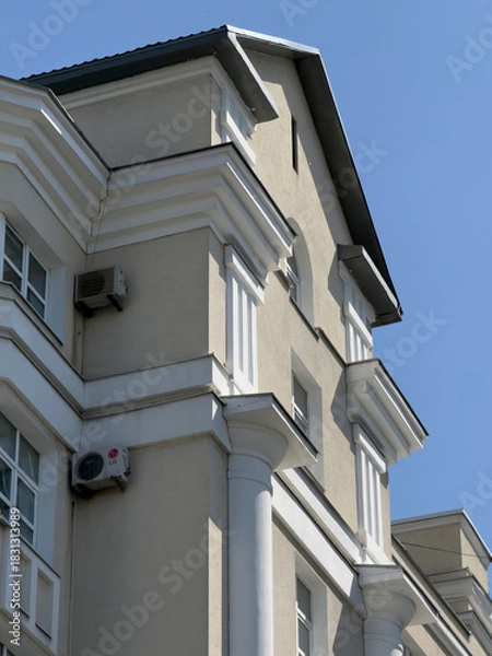 Obraz A tall building showcases elegant design features under a bright blue sky