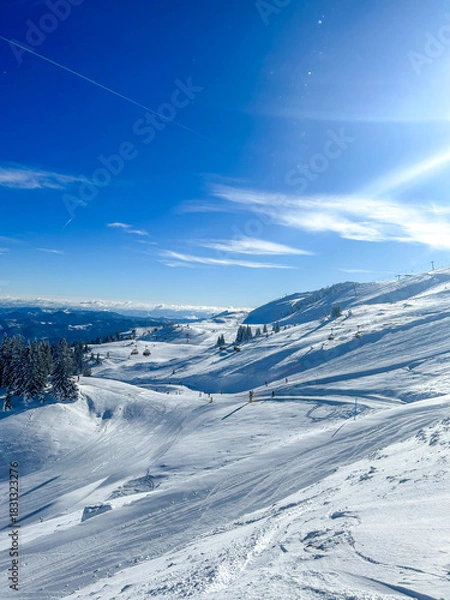 Obraz Idyllic view of the snow-covered slopes of Jahorina, with skiers and a bright blue sky. A perfect scene for promoting winter tourism and active holidays.