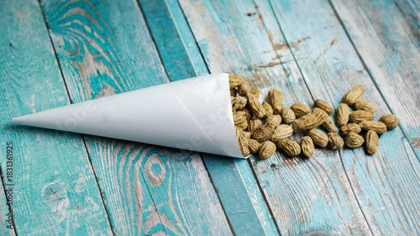 Fototapeta Boiled peanuts wrapped in cone-shaped paper on a rustic table
