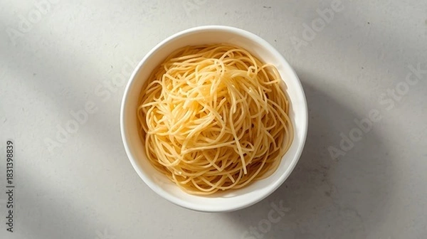 Obraz Overhead view of a white oval bowl filled with golden spaghetti pasta