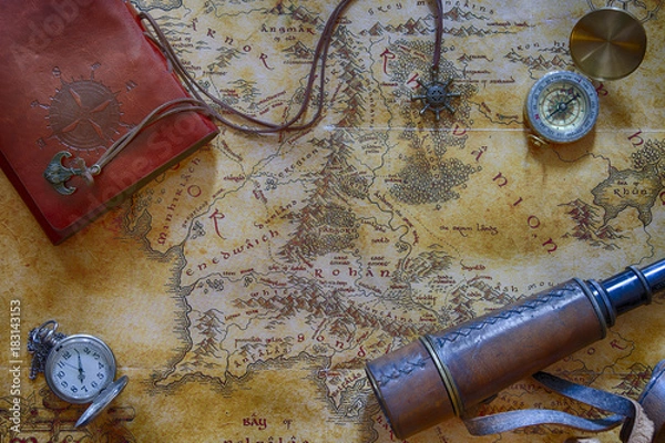 Fototapeta Ancient map (possibly pirate or treasure or middle-earth) with adventure attributes stuff (compass, notepad, telescope and pocket watch) around the perimeter