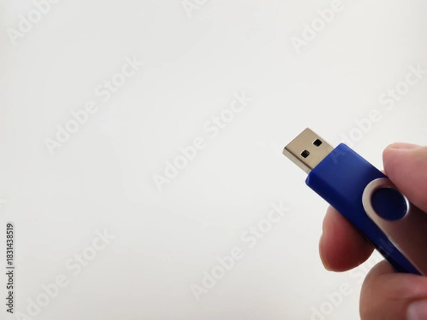 Fototapeta Blue Memory Stick in Hand Isolated Against Blank Backdrop Hand Holding Blue USB Flash Drive on White Background