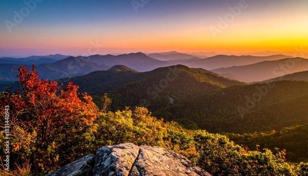 Fototapeta Panoramic view of mountain ranges at dusk, bathed in warm sunset hues