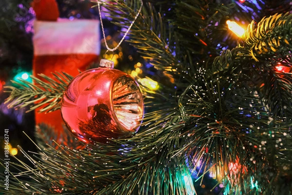 Fototapeta 70's glass globe lantern toy on a Christmas tree with colorful lights