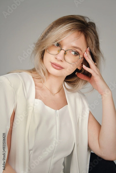 Fototapeta Portrait of a girl in a white suit on a white background. Female portrait.