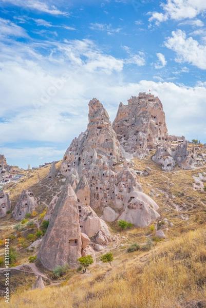 Fototapeta A stunning vertical landscape of Cappadocia, Turkey, showcasing its iconic fairy chimney rock formations and ancient cave dwellings carved into soft volcanic stone