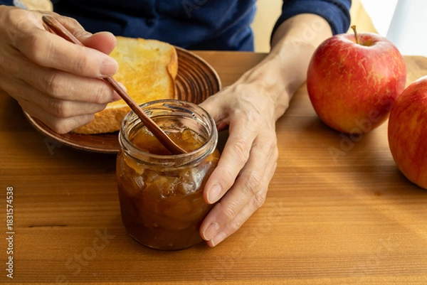 Obraz 手手作りのりんごジャムをパンに塗る女性
