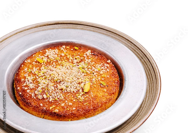 Fototapeta Delicious dessert featuring traditional kunafa topped with nuts and syrup