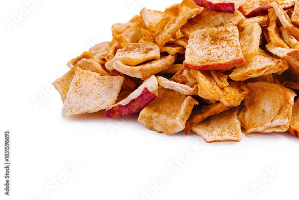 Fototapeta Crispy apple chips stacked on a clean surface in bright light