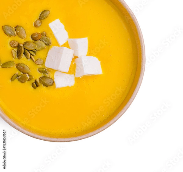 Fototapeta Delicious pumpkin soup topped with cheese and seeds served in a bowl