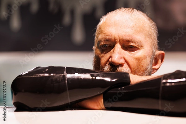 Fototapeta Grey haired diver in wetsuit resting at poolside 