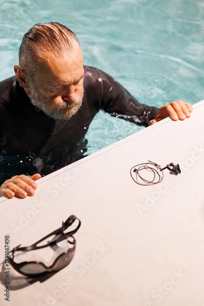 Fototapeta High angle view of diver resting near goggles and nose clip on poolside 