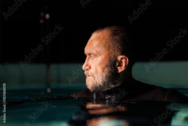 Fototapeta Profile of senior free diver standing in swimming pool 