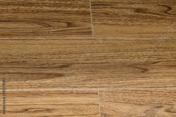 Fototapeta Detailed texture shot of wood-look flooring or tiling, featuring rich, medium-brown tones and defined grain patterns.
