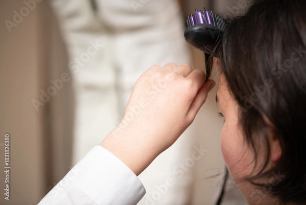 Fototapeta 前髪をセットする女の子の手元