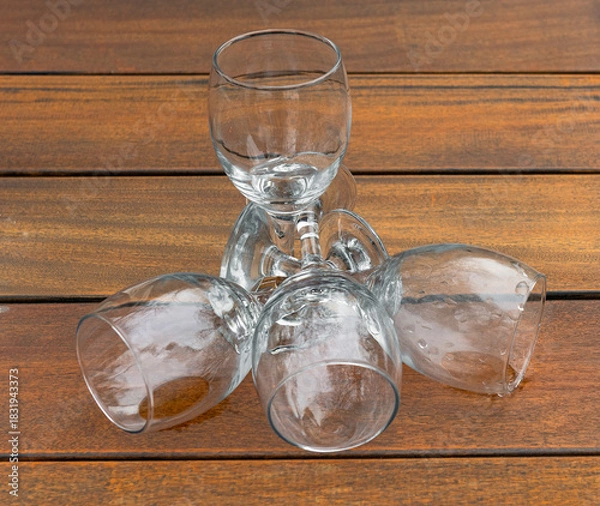 Obraz four wine glasses lie on a wooden table