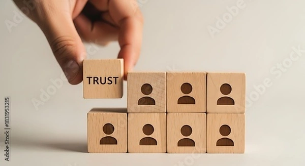 Fototapeta Building trust in a team hand placing a trust block on top of team member blocks for strong leadership