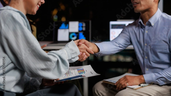 Obraz Business partners making a deal, shaking hands in a meeting, finalizing a partnership in a modern office setup