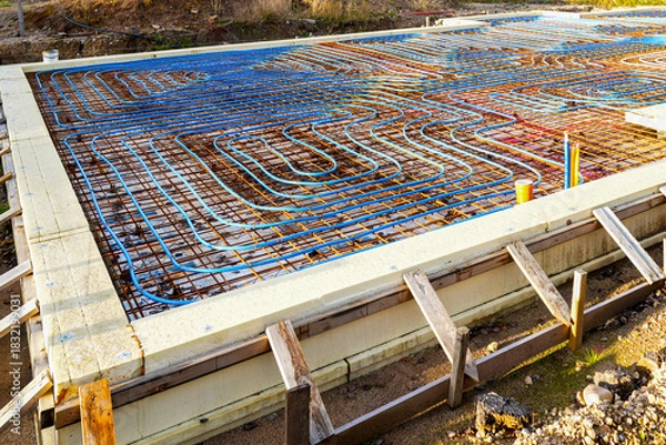 Fototapeta Underfloor heating pipes over reinforced rebar grid before concrete foundation slab pouring