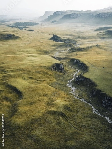 Fototapeta A breathtaking view of a mountainous valley with a winding stream, captured from above. The landscape is rugged and untouched by civilization, creating a serene yet powerful scene.