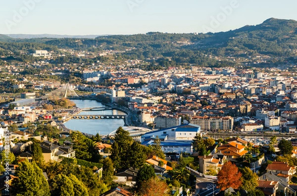 Fototapeta Open view of the historical city of Pontevedra from an elevated viewpoint. Bridges crossing Lerez river during sunset.