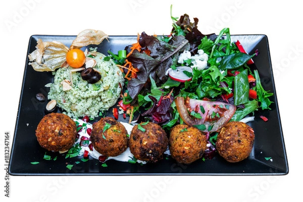Fototapeta Colorful vegan Moroccan tabbouleh served on a black plate, featuring fresh greens, herbs, and flavorful falafel balls, perfect for healthy dining