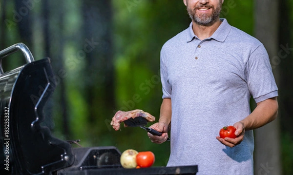 Obraz Chef man do BBQ beef steak. Man cook meat outdoor. Cooking pork meat in backyard. Middle aged man grill meat barbecue. Barbecue and grill. Roasting and grilling food. Hot grill surface
