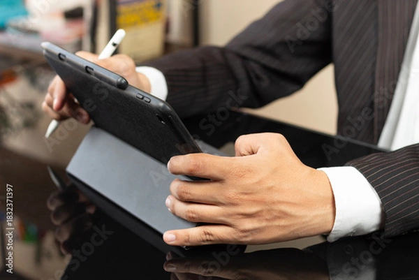Fototapeta a male hands of a CEO on suit working at home on a tablet with a digital pen