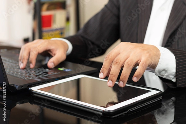 Fototapeta a CEO male hand over a white tablet ready to show something on the space at the right side of the screen