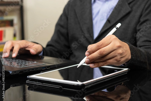 Fototapeta a modern business man working from home ready to draw something on a white tablet with a digital pen