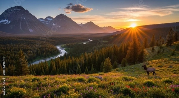 Fototapeta A majestic elk stands in a meadow, surrounded by a vibrant flower-filled field, with a river and mountains in the background under a stunning sunset sky.